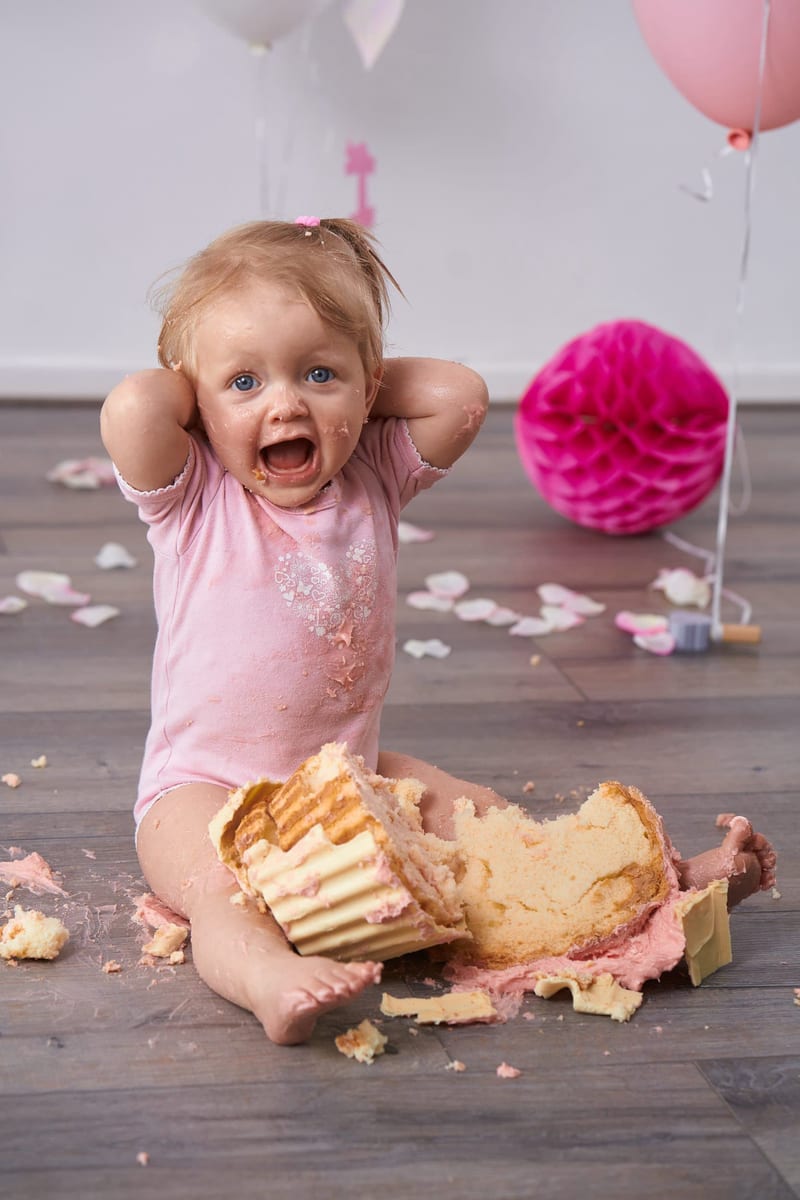 Blij peutermeisje eet cake bij cakesmash fotoshoot, eerste verjaardag babyfotografie Zoetermeer — Familieshoot Stefan Segers