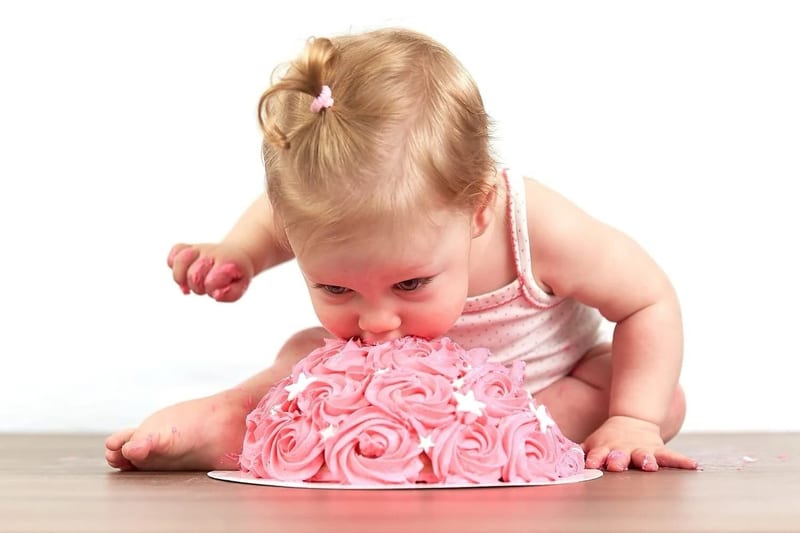 Klein meisje eet roze taart bij cakesmash fotoshoot, eerste verjaardag babyfotografie — Familieshoot Stefan Segers