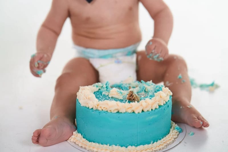 Peuterkind speelt met turquoise verjaardagstaart, cakesmash fotoshoot eerste verjaardag Zoetermeer — Familieshoot Stefan Sege