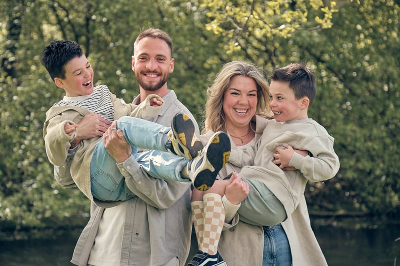 Familie met twee jongens lacht samen in Westerpark, speelse familiefotoshoot buiten Zoetermeer — Familieshoot Stefan Segers