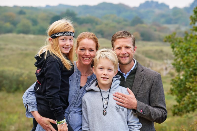 Gelukkig gezin met twee kinderen poseert buiten in natuurgebied Meijendel, warme familiefotoshoot — Familieshoot Stefan Seger