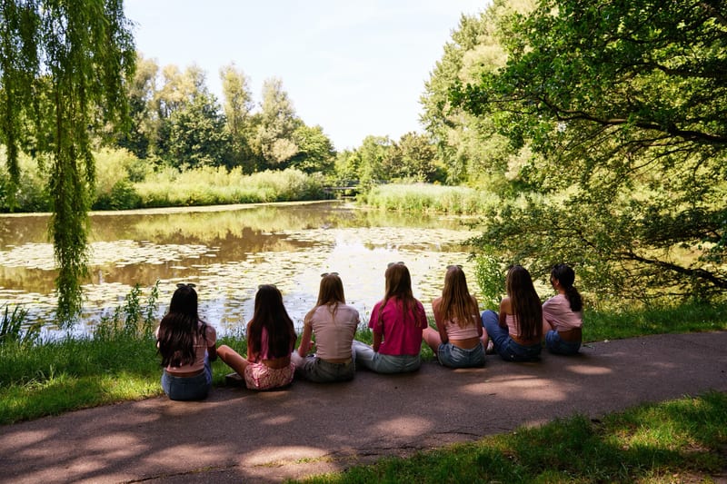 Groep meisjes zit aan oever van meer tijdens kinderfeestje fotoshoot, verjaardag Zoetermeer — Familieshoot Stefan Segers