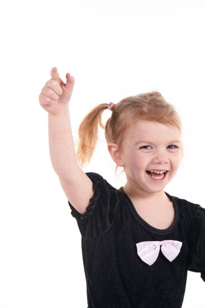 Blij meisje steekt arm in de lucht tijdens kinderfeestje fotoshoot studio, verjaardag Zoetermeer — Familieshoot Stefan Segers