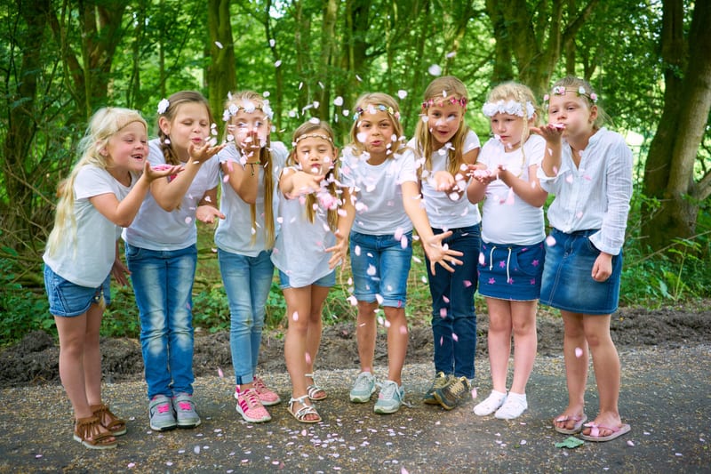 Groep kinderen blaast confetti in de lucht in bos, vrolijk kinderfeestje fotoshoot Zoetermeer — Familieshoot Stefan Segers