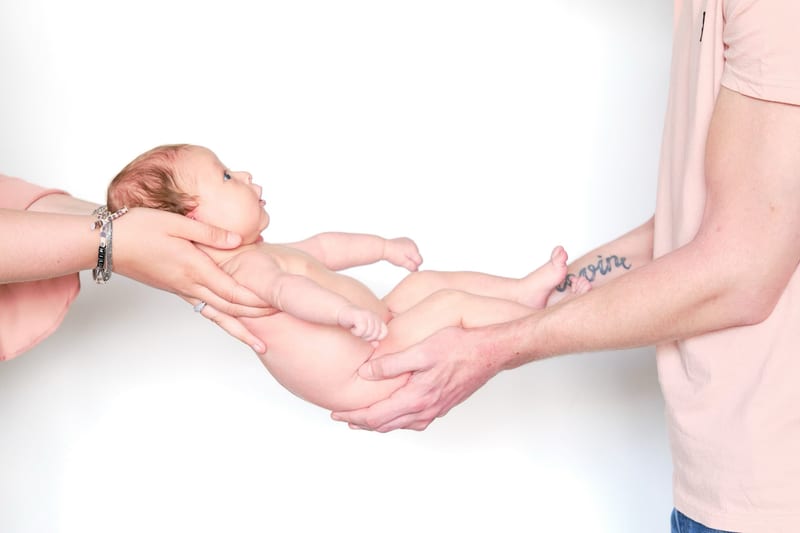 Pasgeboren baby in handen van ouders, tedere newbornfotoshoot fotostudio Zoetermeer — Familieshoot Stefan Segers