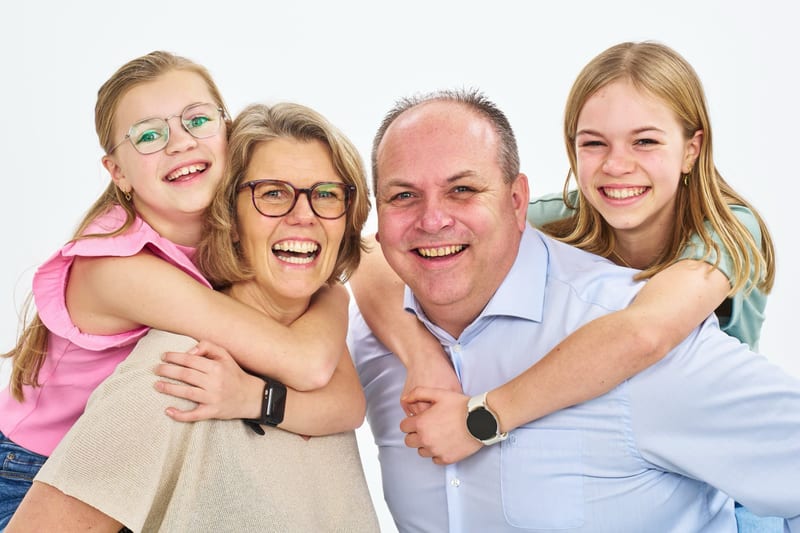 Gelukkig gezin met vader en drie dochters lacht in fotostudio, studiofotografie familieshoot Zoetermeer — Familieshoot Stefan