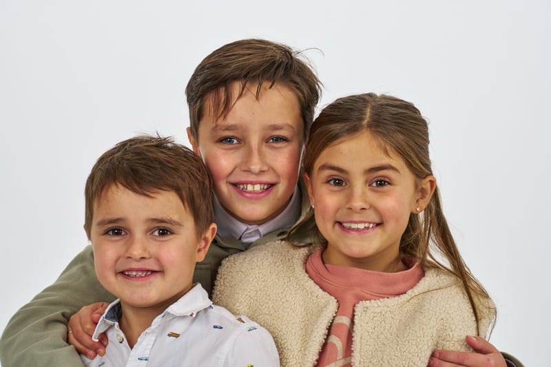 Drie kinderen lachen samen in fotostudio, vrolijke familieshoot Zoetermeer — Familieshoot Stefan Segers