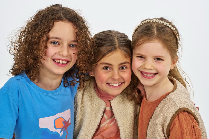 Drie gelukkige meisjes lachen naar camera in fotostudio, studiofotografie familieshoot Zoetermeer — Familieshoot Stefan Seger