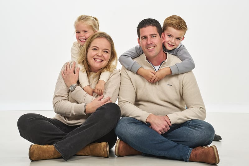 Familie met twee kinderen zit samen in fotostudio, vriendelijk familieshoot Zoetermeer — Familieshoot Stefan Segers