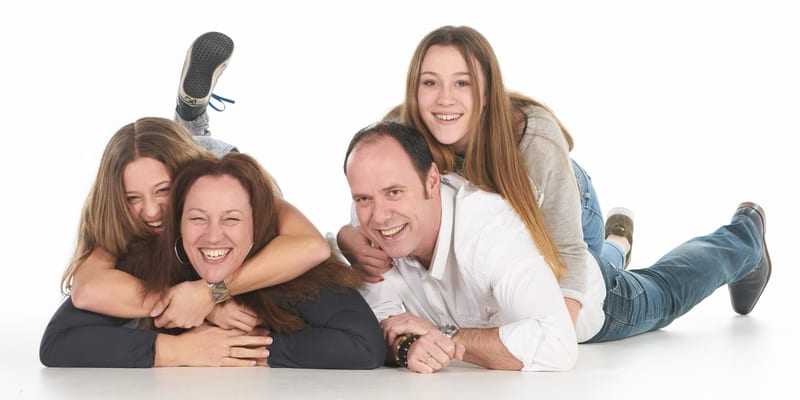 Gelukkig gezin ligt samen op witte achtergrond, studiofotografie fotostudio Zoetermeer — Familieshoot Stefan Segers