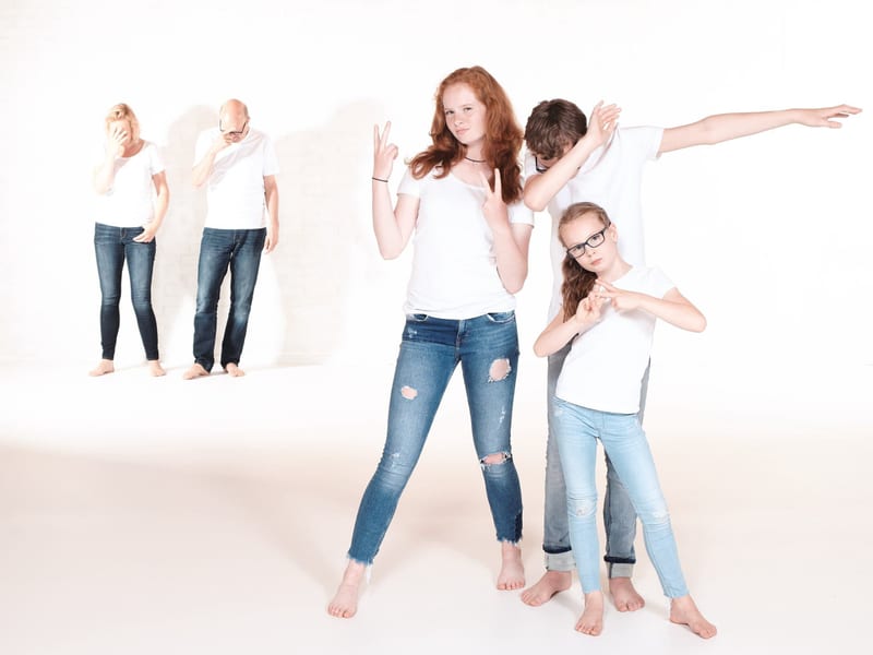 Familie springt vrolijk omhoog in fotostudio, speelse familieshoot Zoetermeer — Familieshoot Stefan Segers