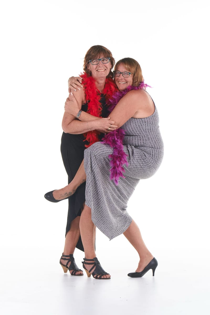Twee vrouwen in feestoutfits met boa's lachen samen, vrijgezellenfeest fotoshoot studio Zoetermeer — Familieshoot Stefan Sege