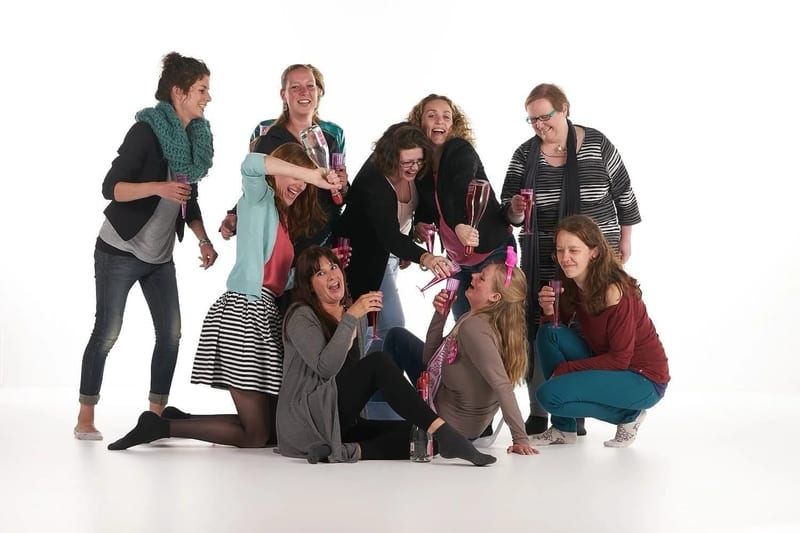 Groep vrienden en bruid vieren samen op vrijgezellenfeest, festief moment in fotostudio — Familieshoot Stefan Segers
