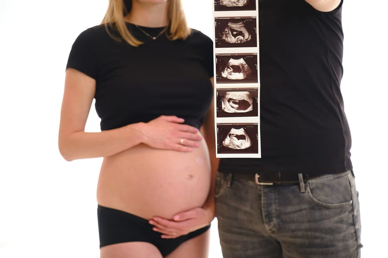 Zwangersschapsfotoshoot in fotostudio, zwanger stel toont buik met echo's, maternity fotografie Zoetermeer — Familieshoot Ste